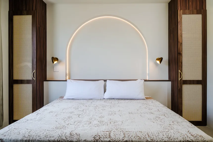 King bed with arched headboard in the Oceanfront King Balcony Suite