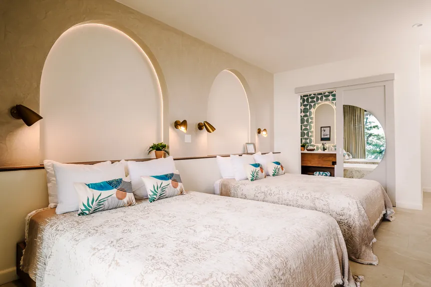 Two queen beds under arched headboards