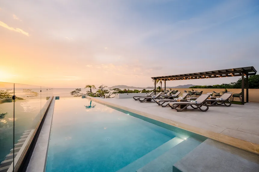 Rooftop infinity pool and sun loungers at sunset