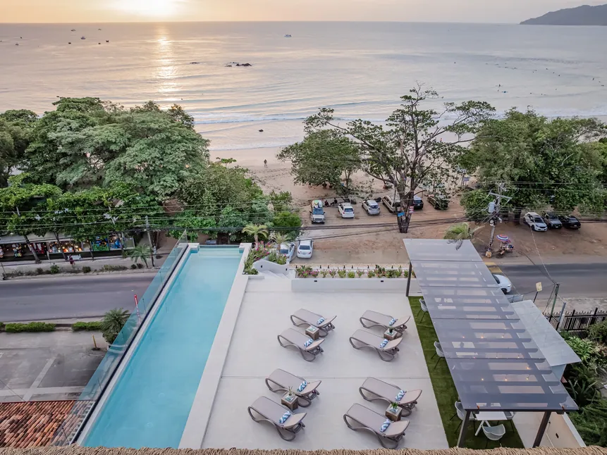 Rooftop pool and sun deck overlooking Tamarindo Beach at sunset