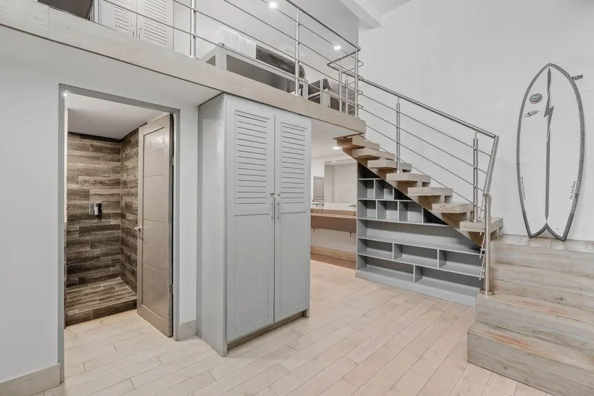 Shared Surf Dorm entry with staircase and surfboard