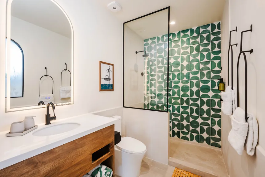 En-suite full bathroom with green tile shower