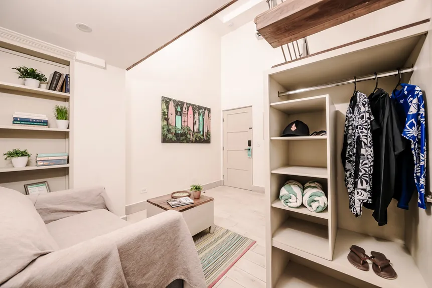 Lounge area and open closet with beach towels in the Surf Loft Suite