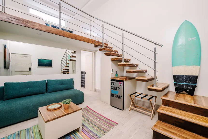 Two-level Surf Loft Suite with lounge sofa and surfboard decor