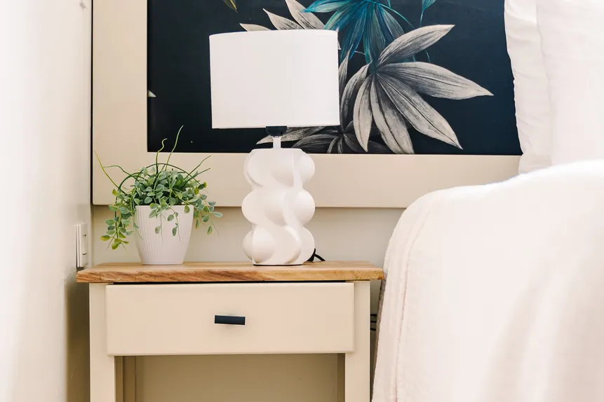 Nightstand with lamp and books in the Surf Loft Suite